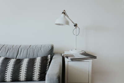 灰色织物沙发旁的白色台灯